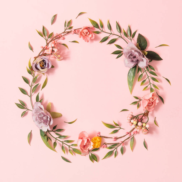 Kreatív tavaszi elrendezés színes virágokkal és zöld levelekkel pasztell rózsaszín háttérrel. Minimális nyári természet koncepció. Lapos fektetés. - Fotó, kép