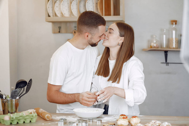 Beautiful couple prepare food in a kitchen - Фото, изображение