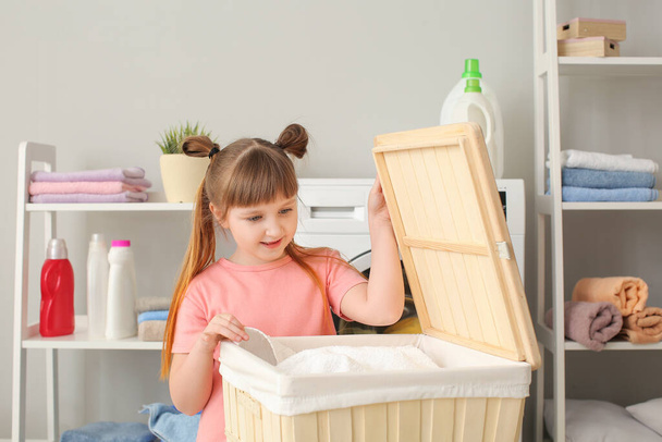 Χαριτωμένο κοριτσάκι κάνει μπουγάδα στο σπίτι - Φωτογραφία, εικόνα