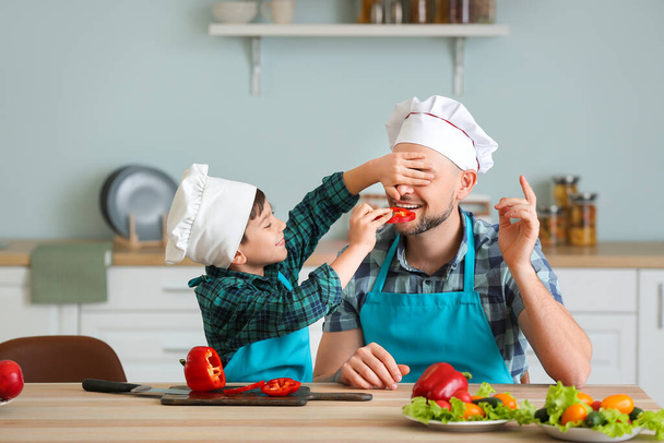 Батько і його маленький син готують на кухні
 - Фото, зображення