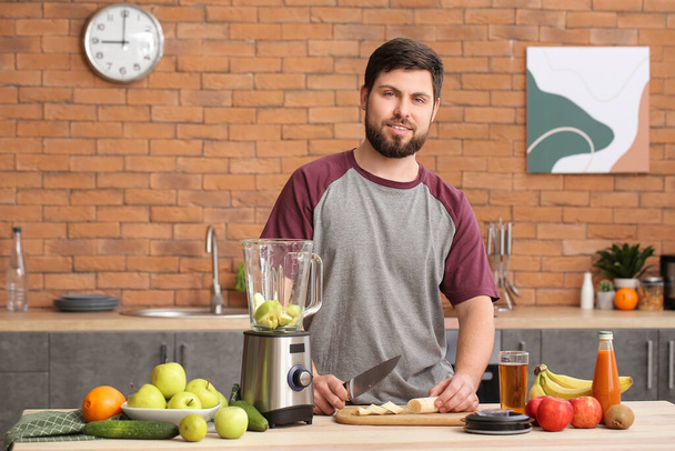 Man making healthy smoothie in kitchen - Valokuva, kuva