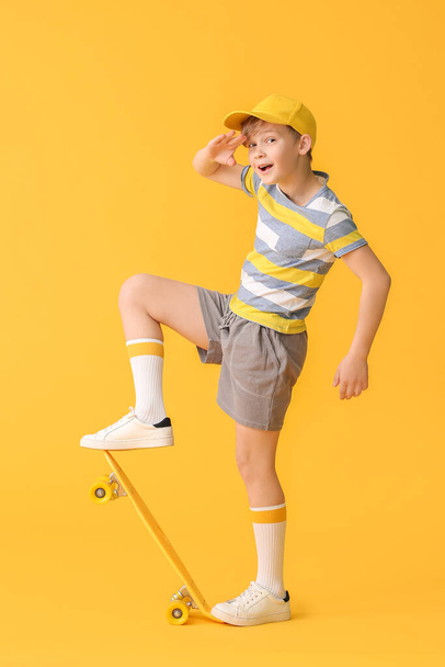 Sportovní malý chlapec s skateboard na barevném pozadí - Fotografie, Obrázek