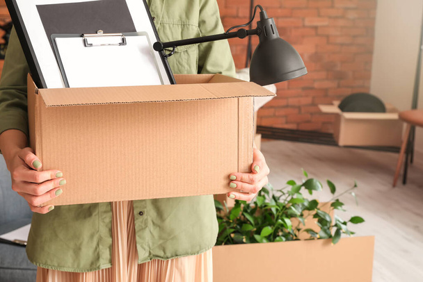 Женщина с вещами в картонной коробке в день переезда
 - Фото, изображение