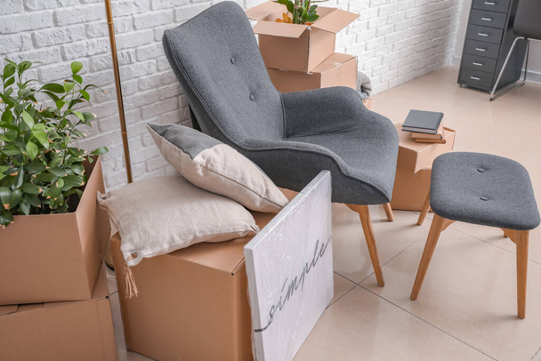 Картонные коробки с вещами и креслом в новой квартире в день переезда - Фото, изображение