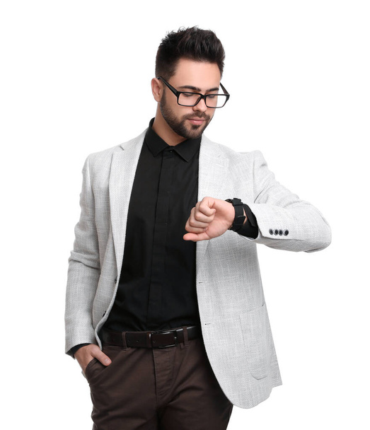 Young businessman checking time on white background - Φωτογραφία, εικόνα