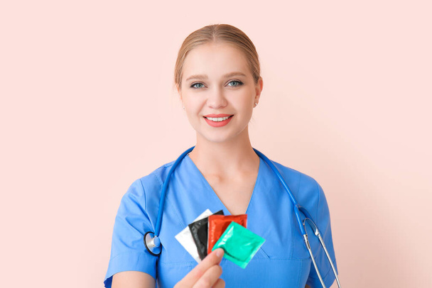 Ginecóloga femenina con preservativos sobre fondo de color
 - Foto, imagen