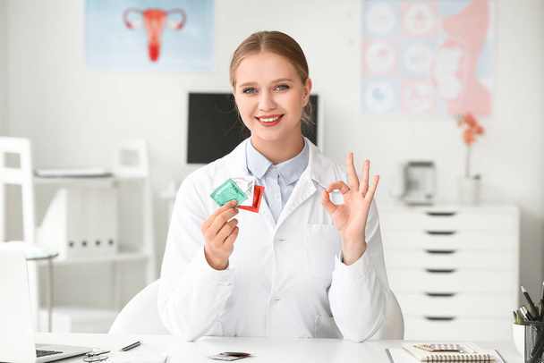 Ginecologista feminina com preservativos na clínica
 - Foto, Imagem