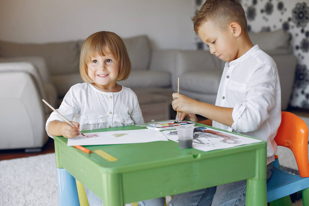 Children siting at the green table and drawing - Foto, imagen