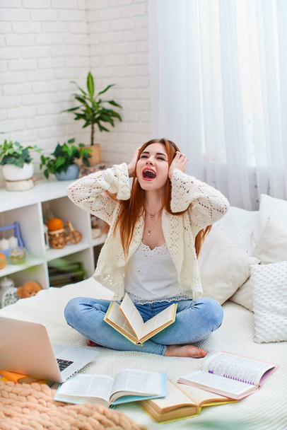 Cute teen girl holding her head and screaming, tired of e-learning. a girl studies online with a laptop, distance learning, self-education in a coronavirus quarantine, covid-19 - Fotó, kép
