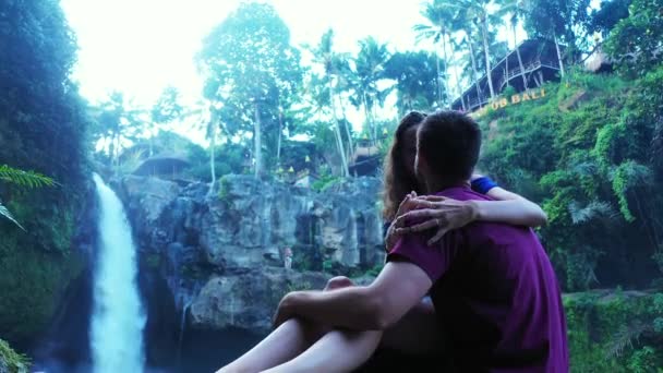 Kaunis tyttö ottaa mukavaa aikaa poikaystävänsä lähellä vesiputous, matkustaa käsite kuvamateriaalia  - Materiaali, video