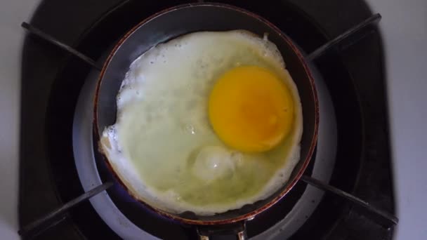 Ev hanımı demir tavada kızarmış yumurta pişiriyor. - Video, Çekim