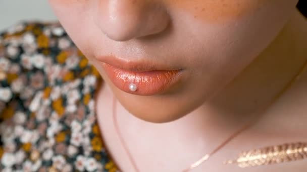 Professionele make-up kunstenaar zet een stukje parel op haar lippen om de look te voltooien. - Video