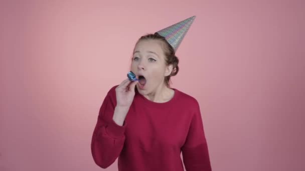 Birthday celebrations. A girl in a cap and a festive horn. - Filmati, video
