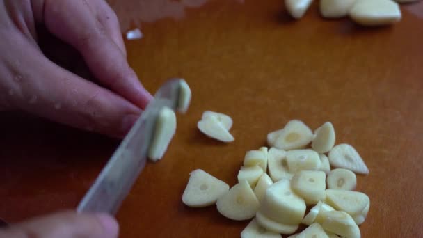 Ο άνθρωπος χέρι χρησιμοποιώντας μαχαίρι για να κόψει το σκόρδο - Πλάνα, βίντεο