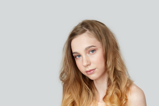Portrait of a beautiful young girl with bright wavy hair. Blonde - Фото, зображення