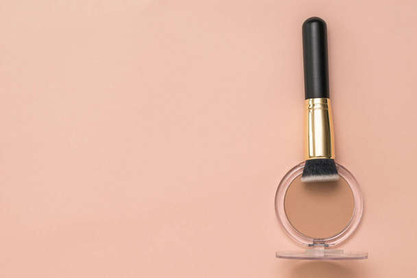 Makeup brush in a jar with powder on a pastel background. - Zdjęcie, obraz