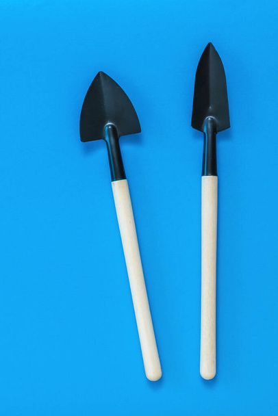 Shovels for digging and removing weeds on a blue background. - Фото, изображение