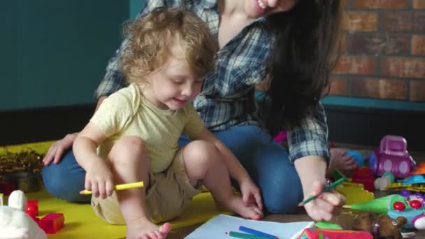 Mother and daughter draws in a notebook on the floor - Footage, Video