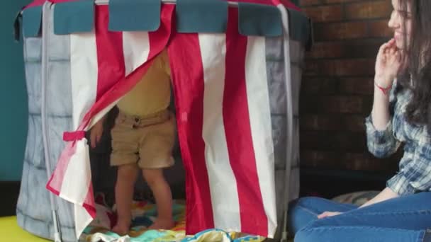 Klein schattig meisje met blond haar spelen in speelgoed huis - Video