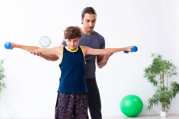 Jovem pai e seu filho fazendo exercícios
 - Foto, Imagem
