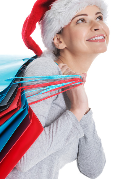 Beautiful woman in santa hat with shopping bags. - Fotó, kép