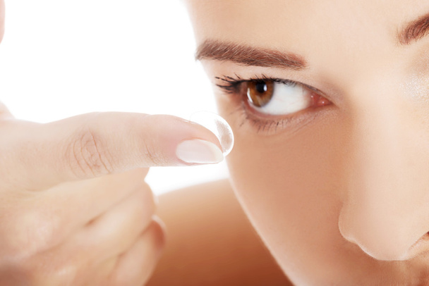 Close up on woman putting lens into eye. - Fotografie, Obrázek