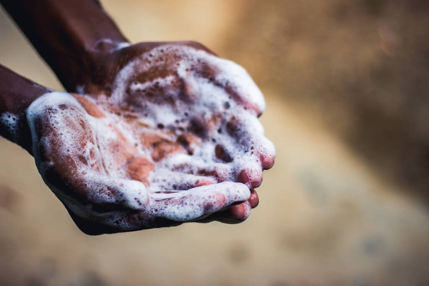 Lavarse las manos. El hombre lavándose las manos en el jardín en casa. La prevención pandémica del virus Corona lava las manos con agua tibia y jabón y frota con frecuencia las uñas y los dedos. Higiene y limpieza de manos
. - Foto, imagen