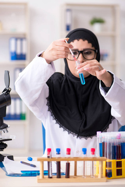 Γυναίκα χημικός με μαντίλα που δουλεύει στο εργαστήριο. - Φωτογραφία, εικόνα