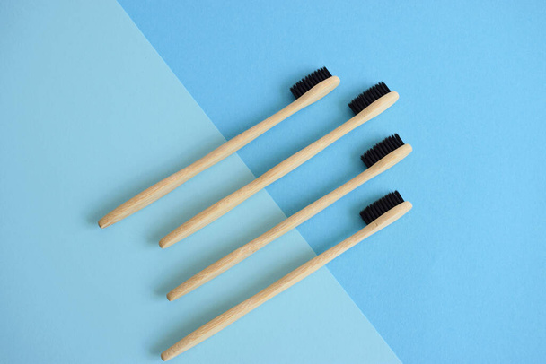 Composizione flat lay con spazzolini in bambù su fondo azzurro e blu
 - Foto, immagini