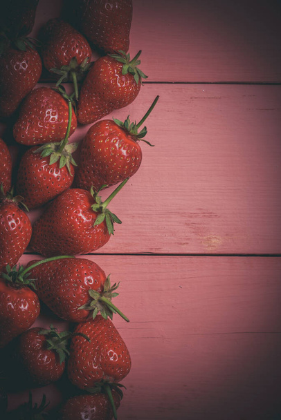 Ripe red strawberries on a pink wooden background - Foto, imagen