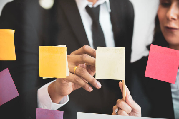 Diversity ethnicity professional businesspeople having a brainstorm and discussing together in their workplace, collaboration and teamwork in expertise businessperson. Businesspeople use sticky note. - Foto, Bild