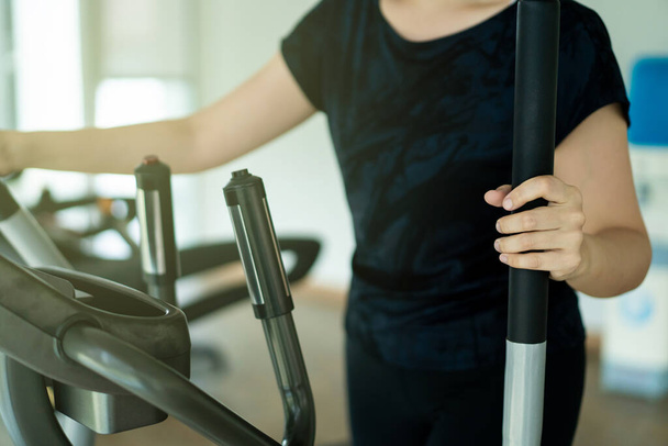 Mulher gorda asiática usando máquinas de exercícios em ginásio indoor, esporte retrato da mulher asiática com espaço de cópia
. - Foto, Imagem