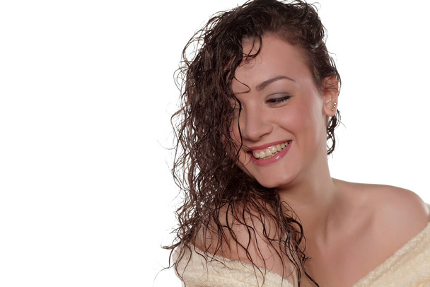 mosolygó fiatal nő fürdőköpenyben nedves hajjal - Fotó, kép