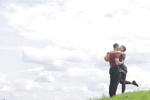 love couple in helmets outdoor activities nature, rope climbing park, against the sky - Foto, Imagen