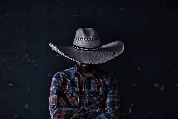 stern cowboy in a hat with brim, straw, retro vintage style, angry man wild west western - Fotoğraf, Görsel