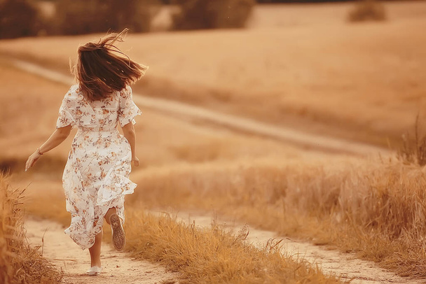 girl runs on a summer field in a dress wheat, sunset sunny day concept freedom happiness - Fotoğraf, Görsel