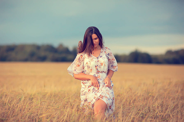 girl runs on a summer field in a dress wheat, sunset sunny day concept freedom happiness - Foto, Imagen