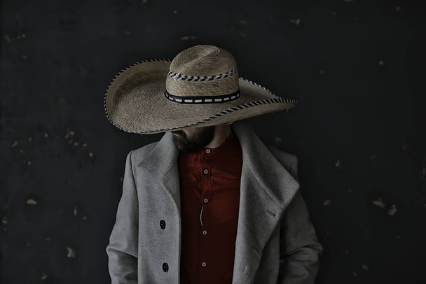 mężczyzna w kapeluszu ze słomkowym rondem, ukrywa twarz, incognito facet, abstrakcyjny styl muzyki country america west - Zdjęcie, obraz