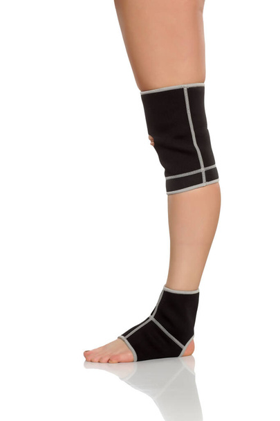 жіноча нога з брекетом для коліна і щиколотки
 - Фото, зображення
