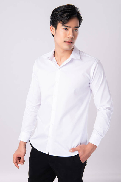 Handsome man wearing a white shirt on white background, - Foto, Imagen