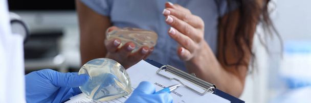 Kosmetologi lääkäri täyttää sopimuksen ja potilaan toiveet
 - Valokuva, kuva