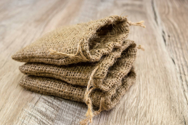 bags with burlap on a wooden background. - Photo, Image