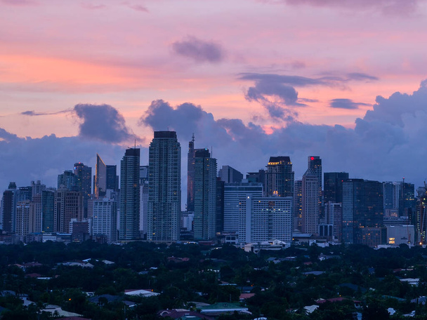 Makati, Metro Manila, Philippinen: Nachmittags Skyline mit rosa Himmel und Wolken und Dasmarinas Village. - Foto, Bild