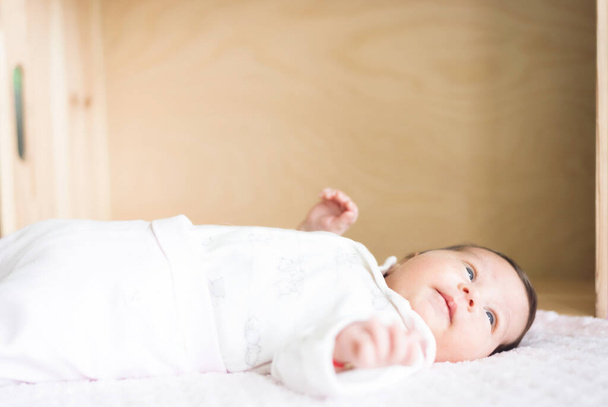 乳児の美しい赤ちゃんの白い毛布の上に横たわっ。コピースペース付きの画像 - 写真・画像