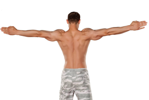 rear view of the half-naked handsome and muscular young man posing on a white background - Photo, Image