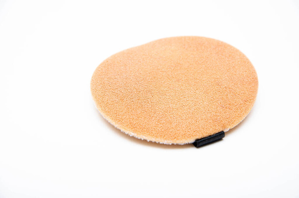 Beige spons voor poeder, make-up op een witte achtergrond in macro- en bovenaanzicht - Foto, afbeelding
