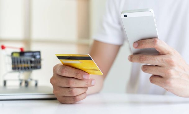 Männer nutzen Smartphone, um Online-Einkäufe mit Kreditkartenzahlung zu registrieren, Komfort in der Welt der Technologie und des Internets, Online-Shopping und Online-Banking-Konzept. - Foto, Bild