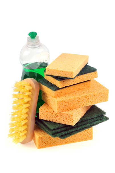 Esponjas com uma escova e produto doméstico close-up em um fundo branco
 - Foto, Imagem