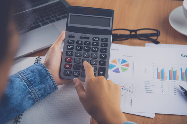 The accountant's hand is using the calculator. For cost analysis Profit and loss and tax calculation concept preparation of financial statements - Фото, зображення