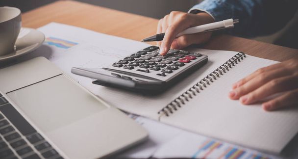 The accountant's hand is using the calculator. For cost analysis Profit and loss and tax calculation concept preparation of financial statements - Fotoğraf, Görsel
